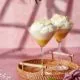 zwei Martini gläser gefüllt mit frischer ananaspüree und einer Mousse aus Batida de coco und sahne.